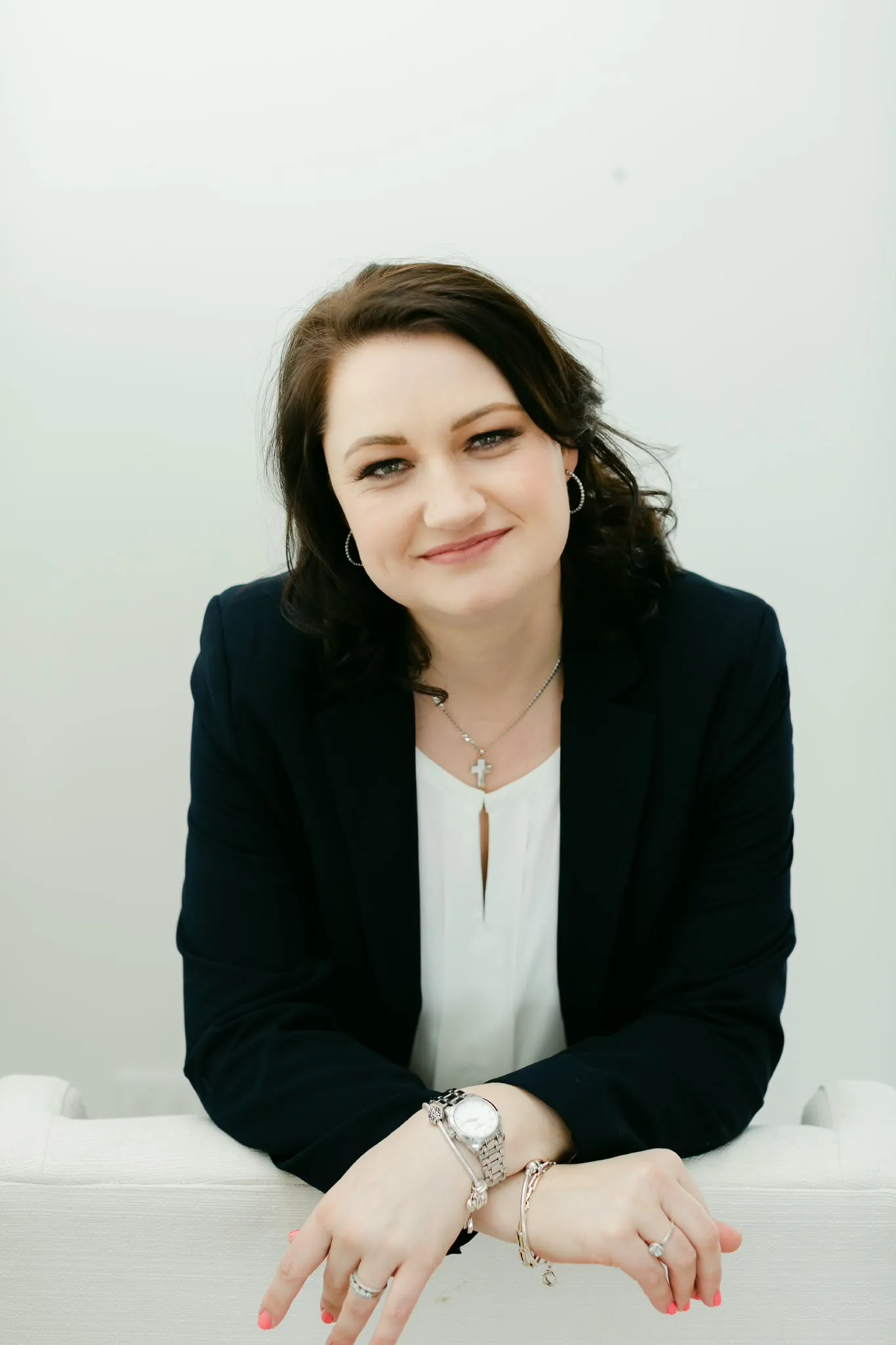 Portrait of Annelize du Toit seated in an armchair, wearing a navy blazer